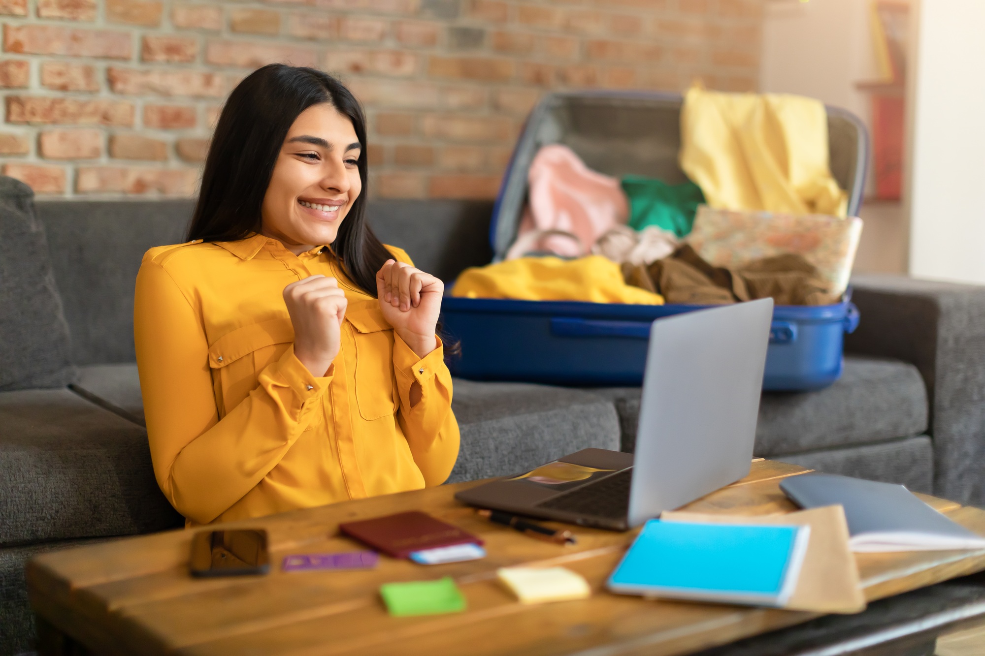 Overjoyed spanish lady booking hot tour online on laptop computer, excited over huge sale in tourist